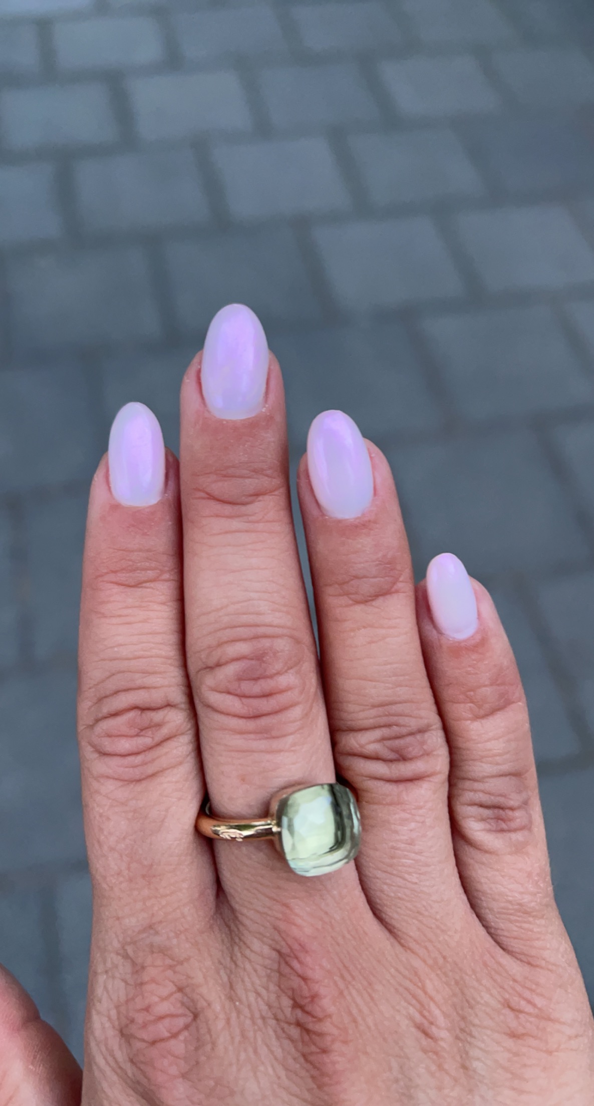 Lila nagels op een hand met een ring