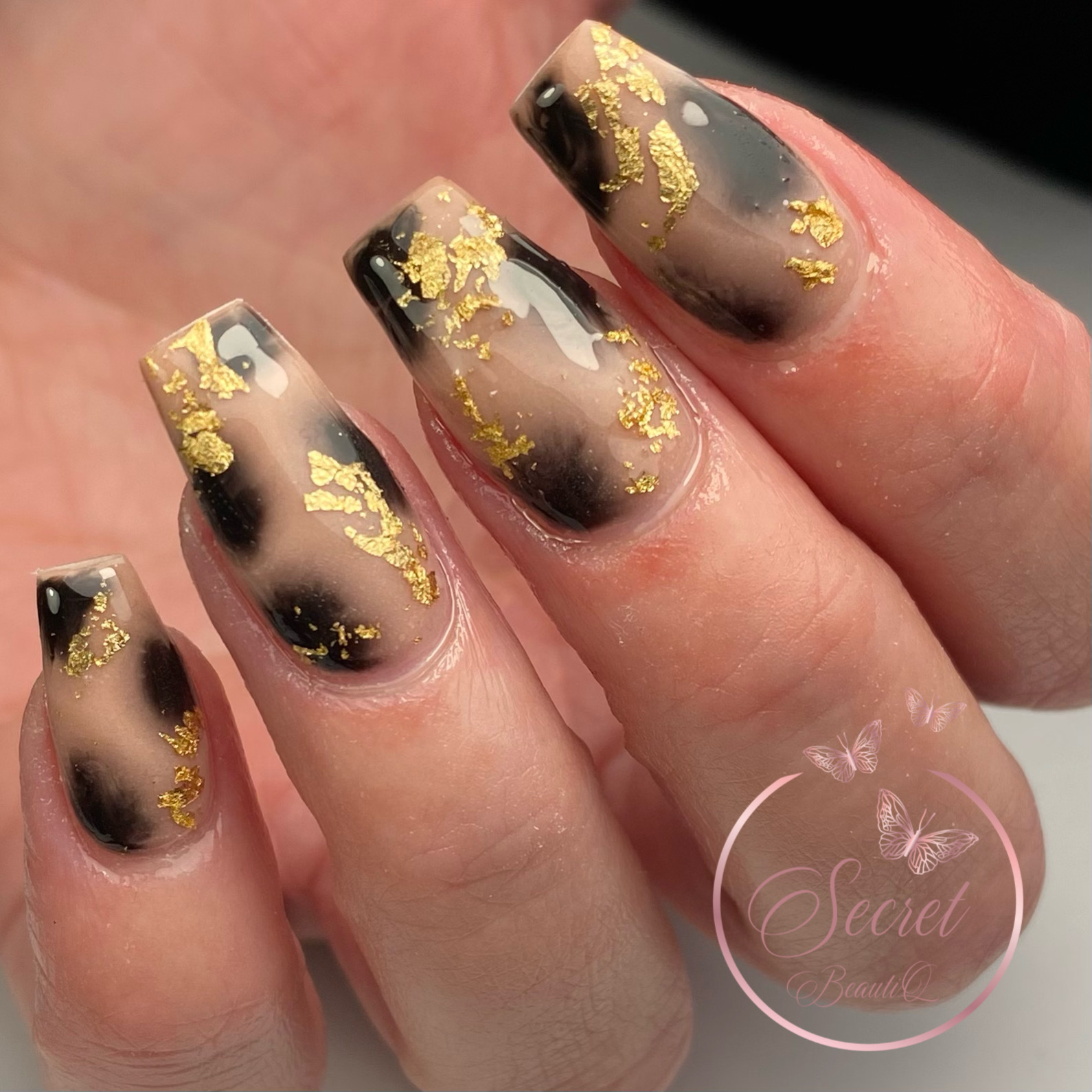 Zwarte nagels met gouden folie in een ombre naar nude